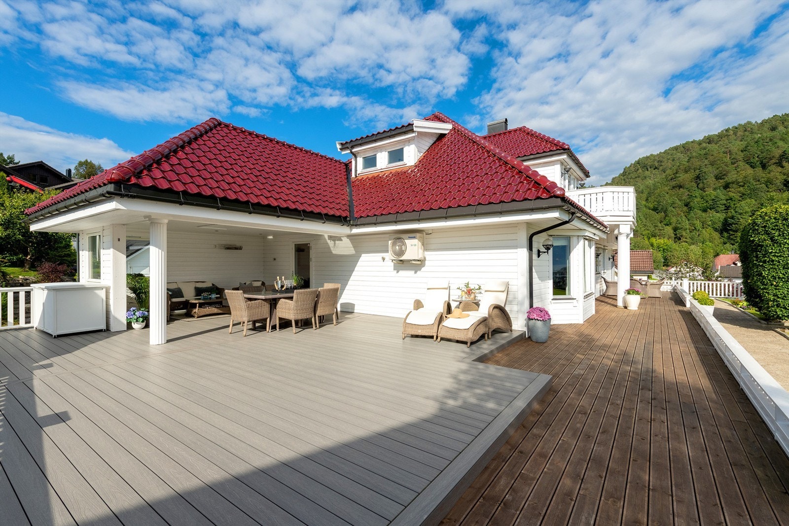 Stor treterrasse på terreng med god plass til flere soner og sitteplasser. Galleribilde