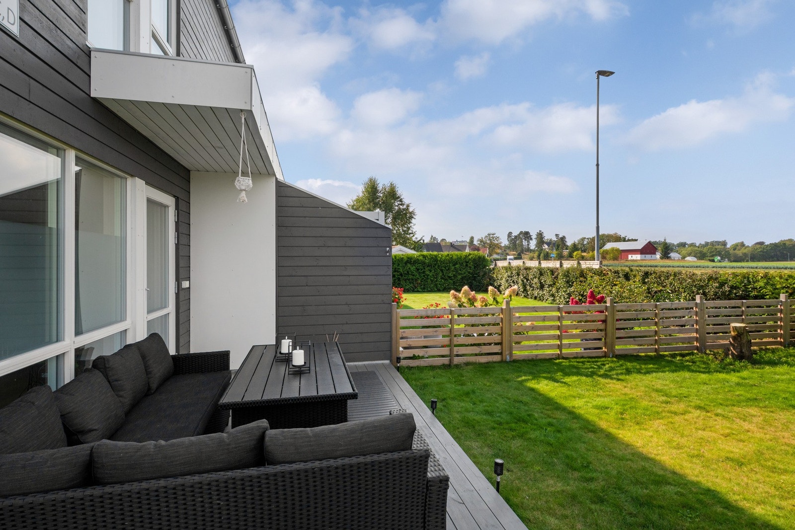 Her er det høyt under taket, og terrassen har utestikk, downlights og levegg mot naboen. Galleribilde