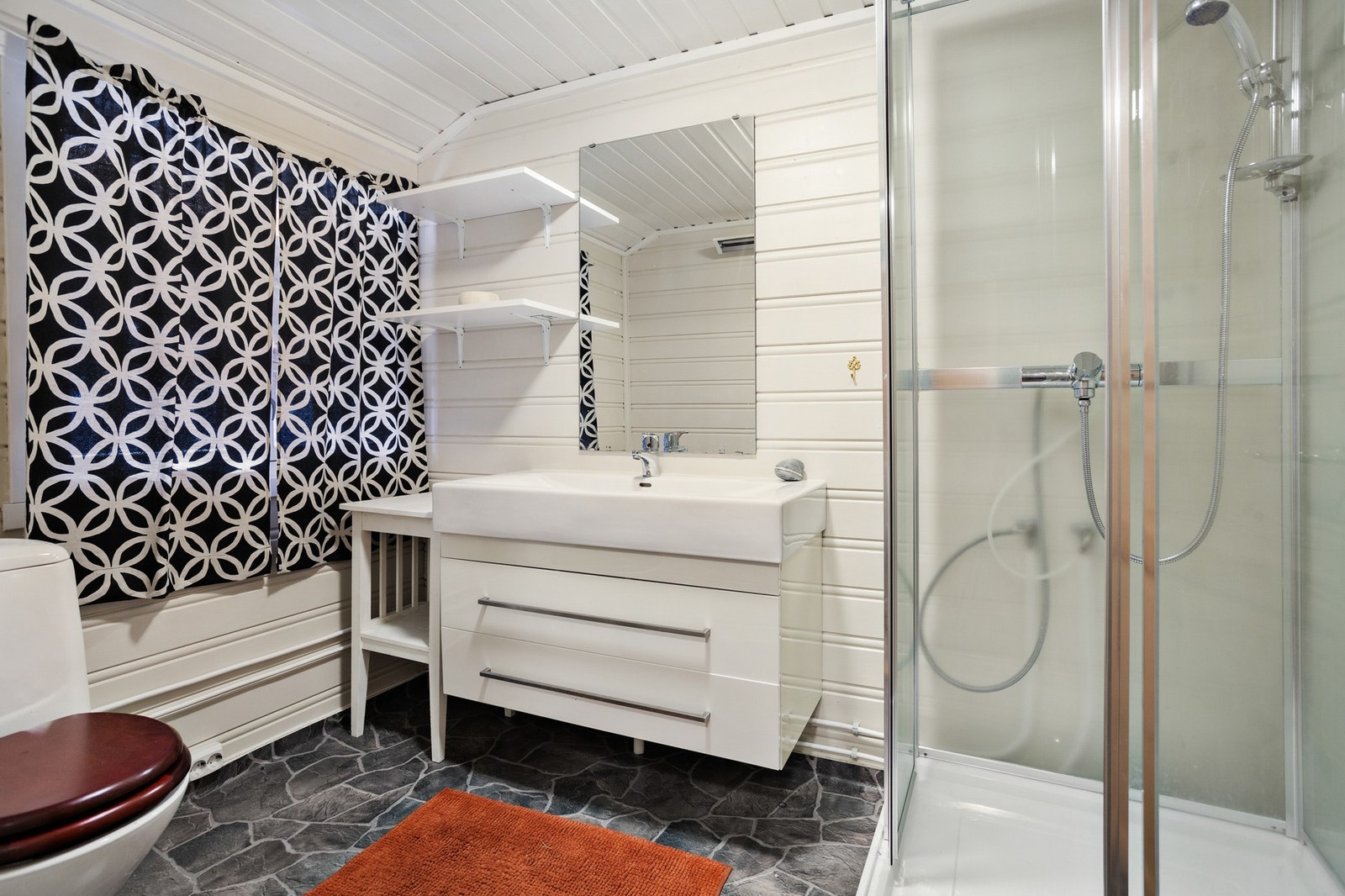 Badet har naturlig ventilasjon og panelovn som varmekilde. Badet har dusjkabinett og vinylbelegg - enkelt og praktisk. Galleribilde