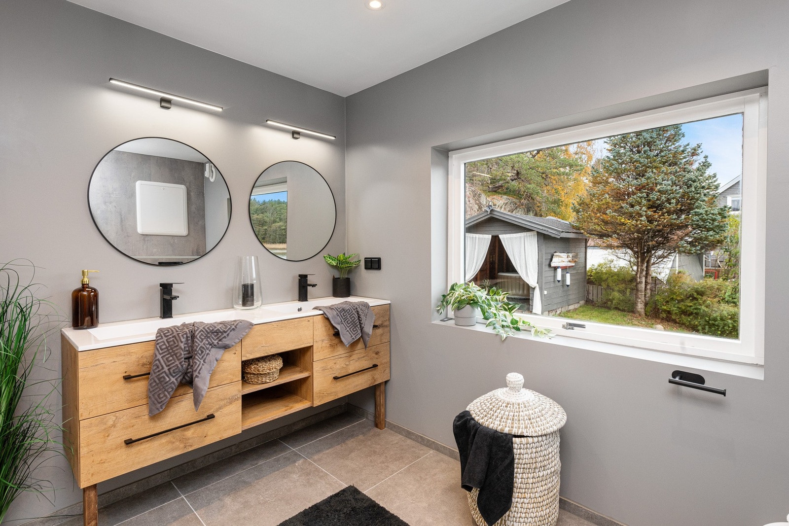 Baderommet er innredet med dusjhjørne med glassvegg, vegghengt toalett, dobbelvask med underskap med overlys. Opplegg for vaskemaskin. Galleribilde