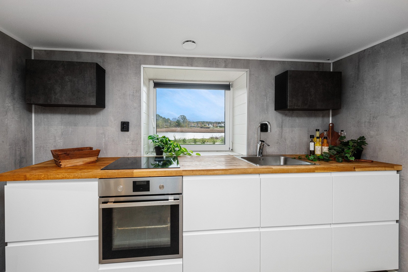 Kjøkken er innredet med nedfelt oppvaskkum med ett-greps armatur, integrert stekeovn og integrert oppvaskmaskin og overskap over benkeplate. Galleribilde