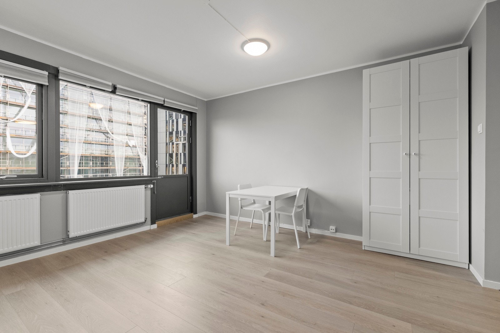 Lys og fin stue med gode møbleringsmuligheter for både sofagruppe og spisemøblement Galleribilde