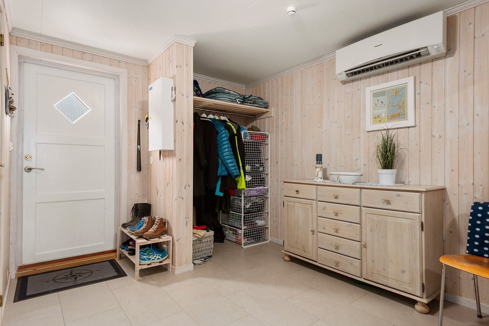 Velkommen inn til en romslig og flislagt hall med gode oppbevaringsmuligheter. Galleribilde