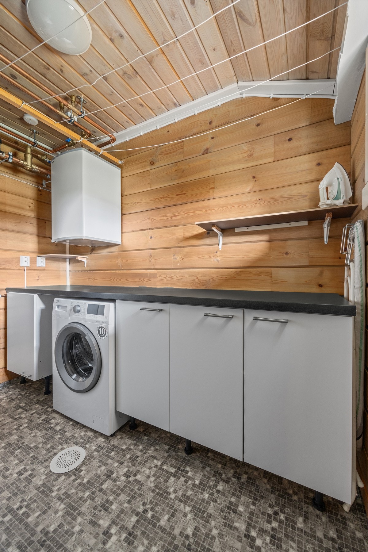 Praktisk vaskeromsinnredning med opplegg for vaskemaskin og utslagsvask. Galleribilde