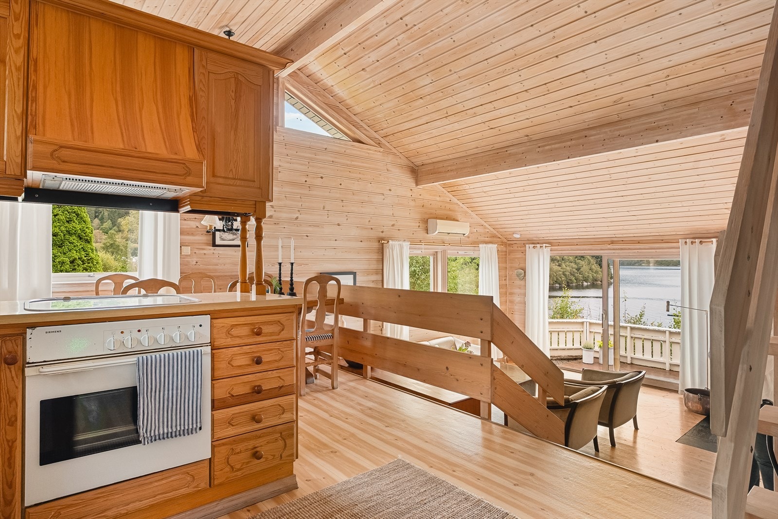 Stue og kjøkken har en åpen planløsning, adskilt av en liten trapp | Halvetasjene skaper flere naturlige sosiale soner Galleribilde