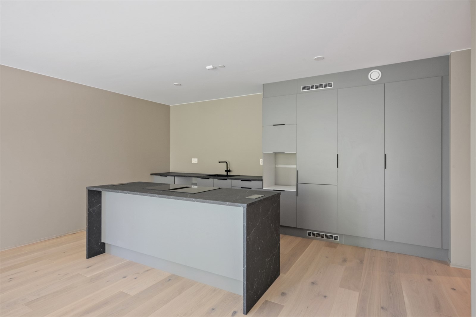 Delikat kjøkkeninnredning i moderne fargevalg med slette skapfronter og romslig kjøkkenøy Galleribilde