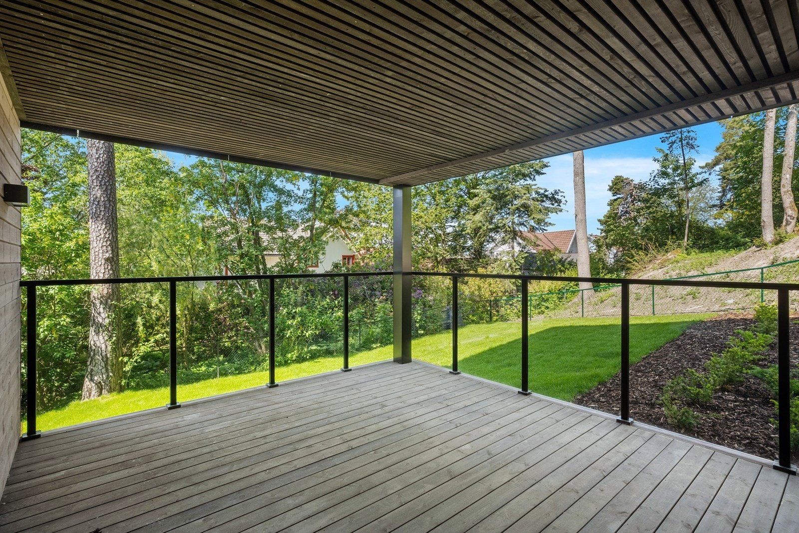 Usjenert og overbygd veranda med utsikt til felles hageområde Galleribilde