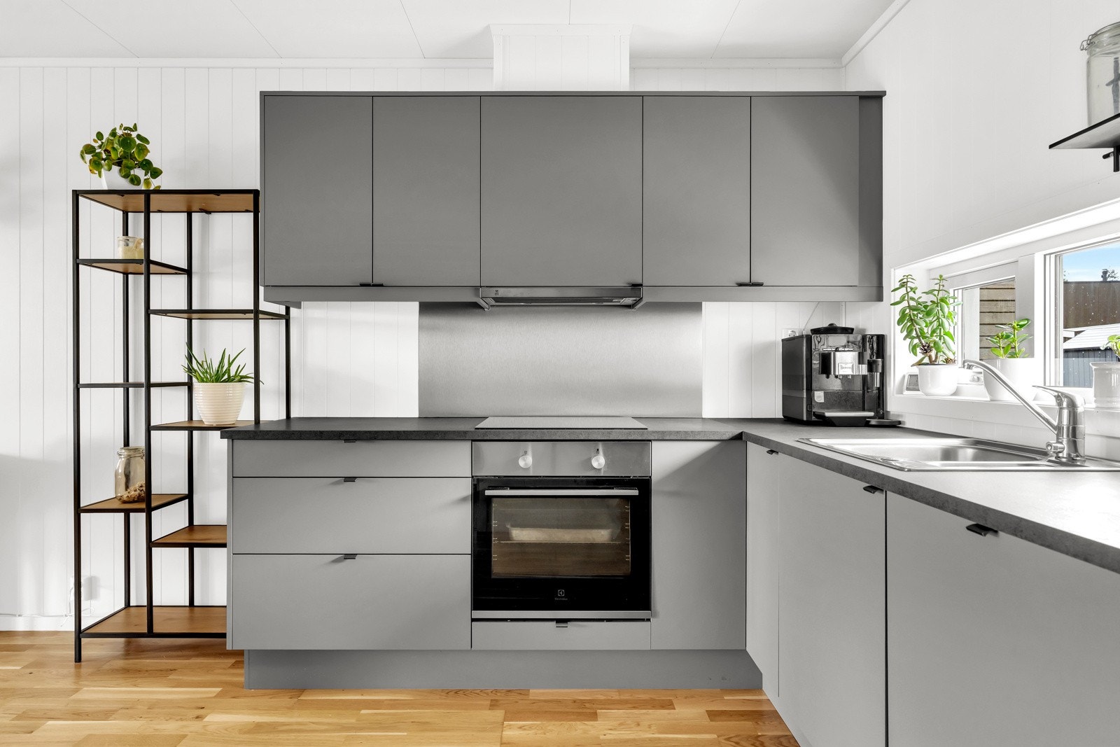 Hvitevarene er integrert og inkluderer kjøleskap med fryser, oppvaskmaskin, stekeovn og platetopp. Her er det rikelig med skapplass og gode arbeidsflater, noe som gjør kjøkkenet både funksjonelt og estetisk tiltalende Galleribilde