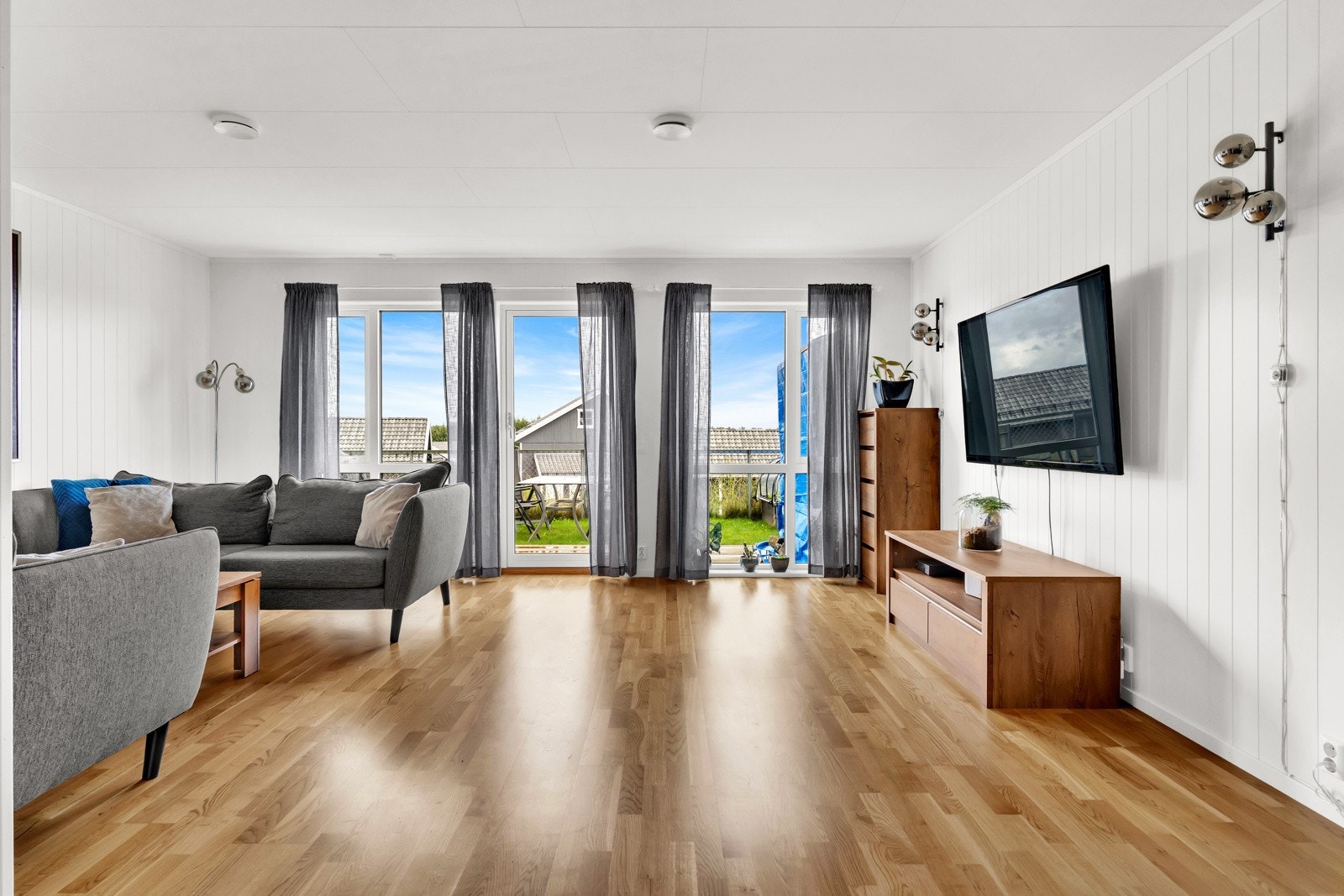 Stuen er et lyst og luftig oppholdsrom med store vindusflater som slipper inn rikelig med dagslys Galleribilde