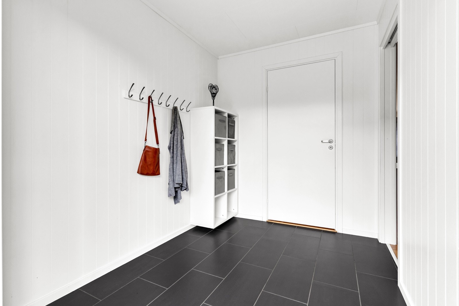 Når du kommer inn møtes du av en romslig og innbydende entré med flislagt gulv, noe som gir et rent og pent førsteinntrykk Galleribilde