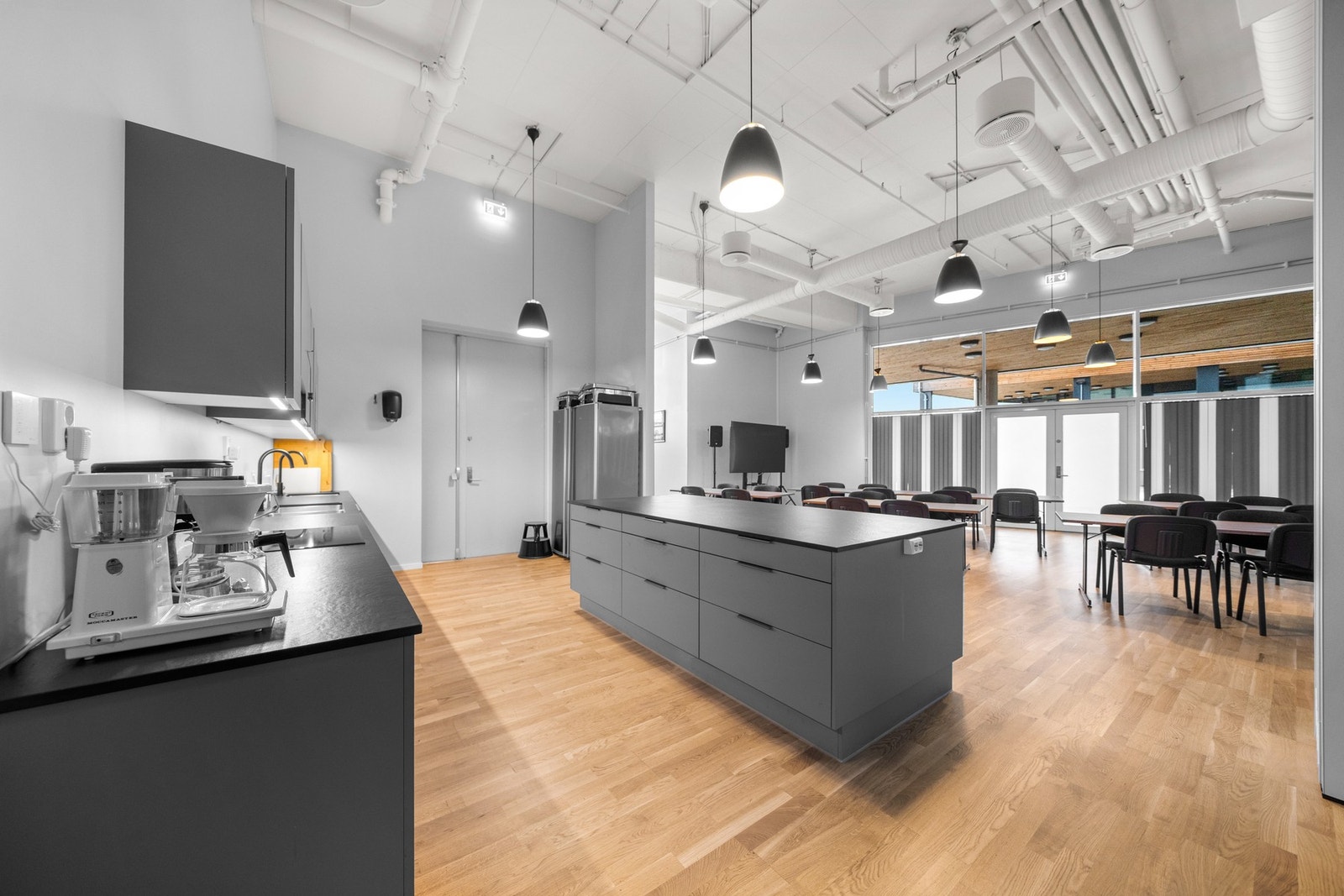 Storstua er møblert og utstyrt med TV, lydanlegg, kjøleskap, liten fryseboks, oppvaskmaskin og ulike redskaper til mat og servering. Galleribilde