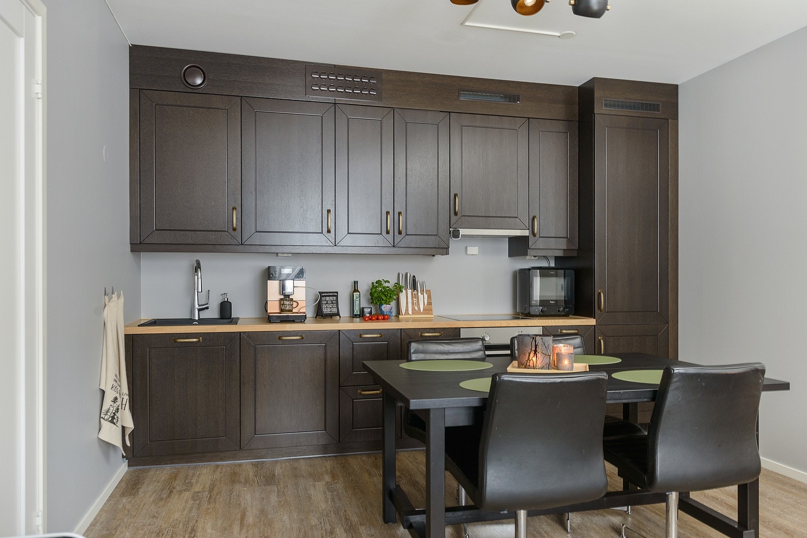 Kjøkkeninnredningen har mørke profilerte fronter og heltre benkeplate med kjøkkenkum. Galleribilde