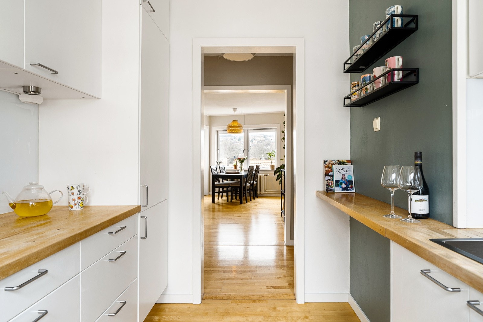 Kjøkkenet har hvite fronter og benkeplater i heltre, det er integrerte hvitevarer som kjøleskap, komfyr og oppvaskmaskin. Galleribilde