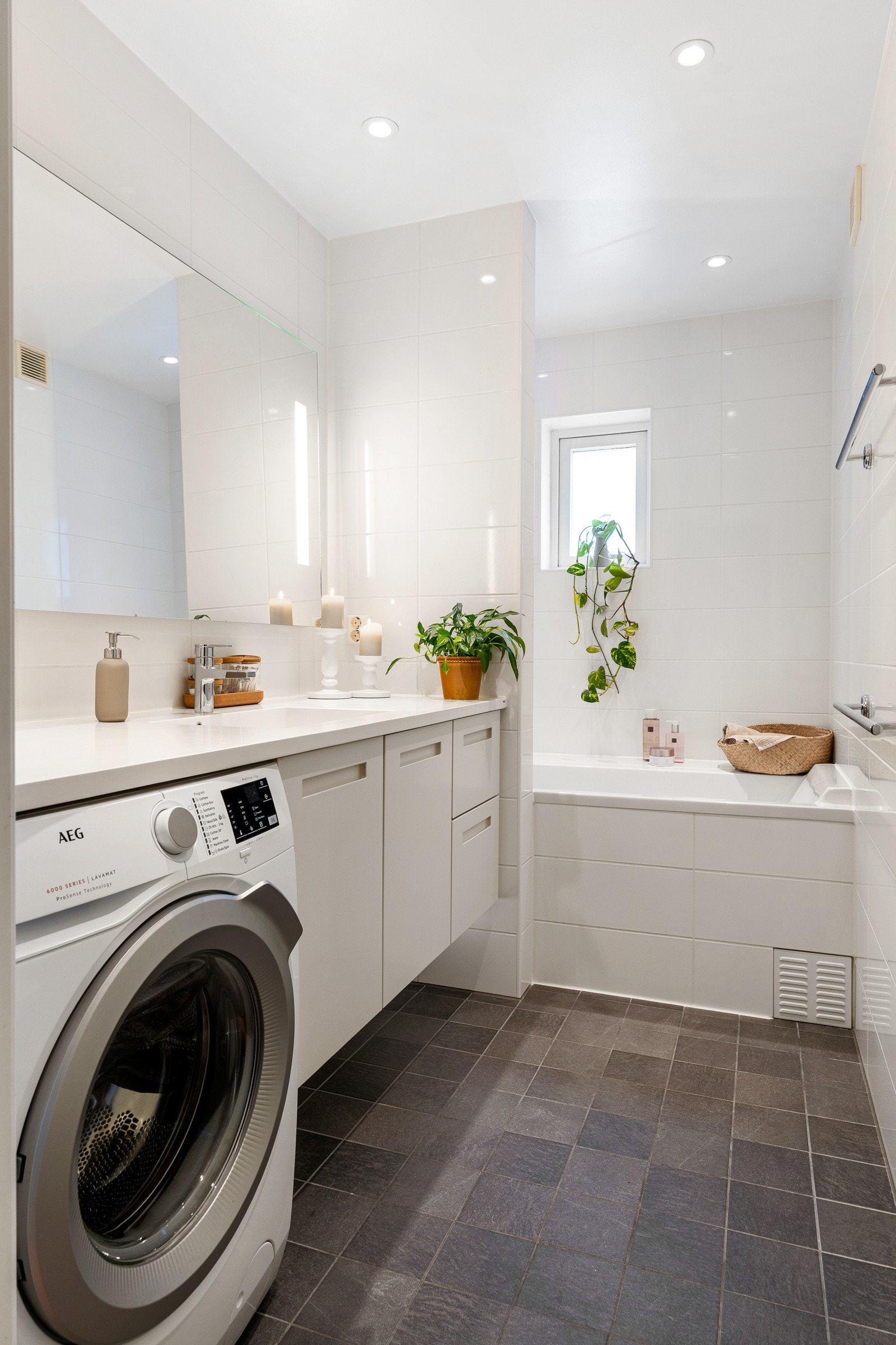 Badet har en flott utførelse og er av god størrelse med sine 5 kvm. Baderomsinnredningen inkluderer servant med underskap, speil med belysning, downlights, opplegg for vaskemaskin og vegghengt toalett . Galleribilde