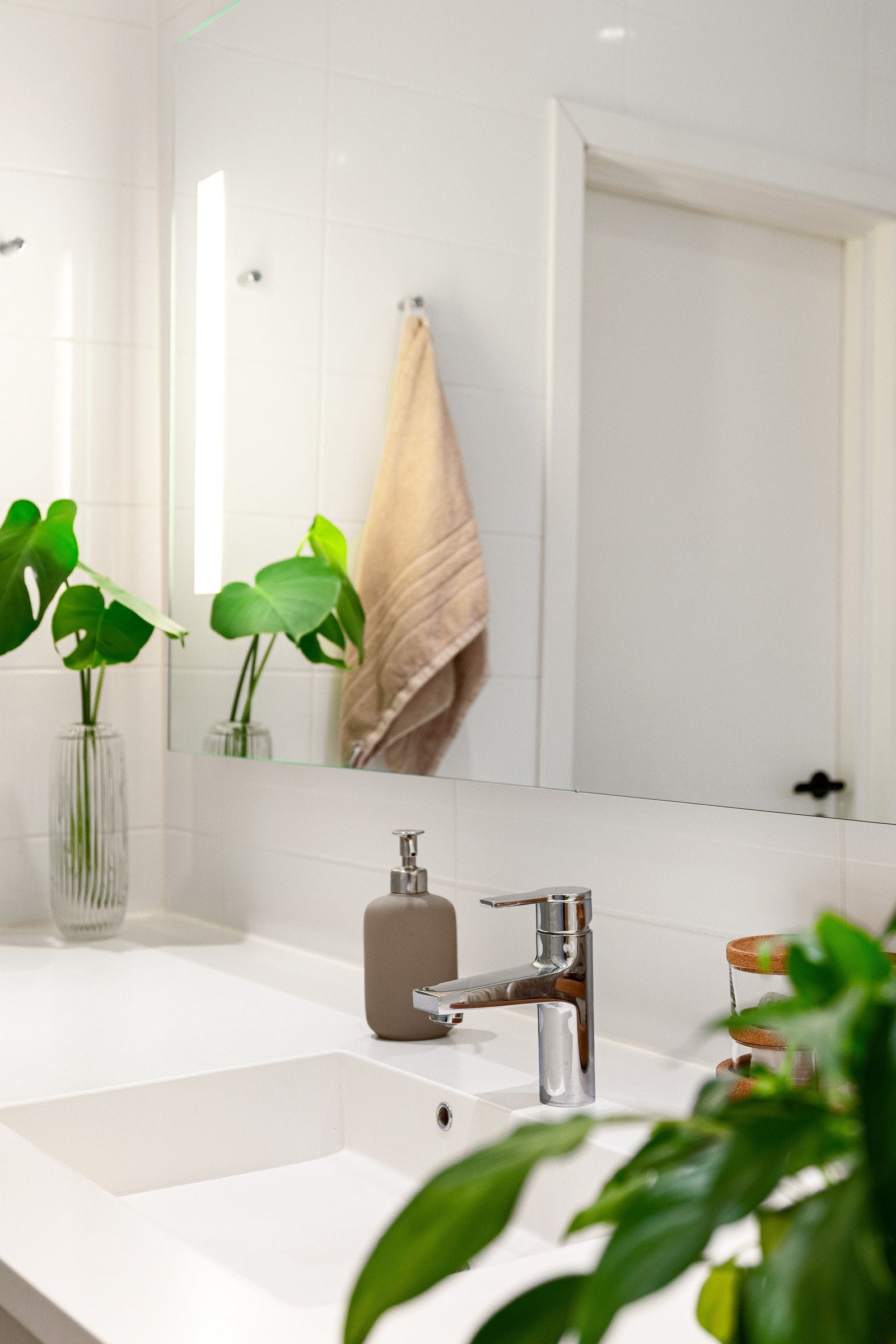 Det er praktisk innredet med flislagte overflater og varme i gulv samt en stilren baderomsinnredning. Galleribilde