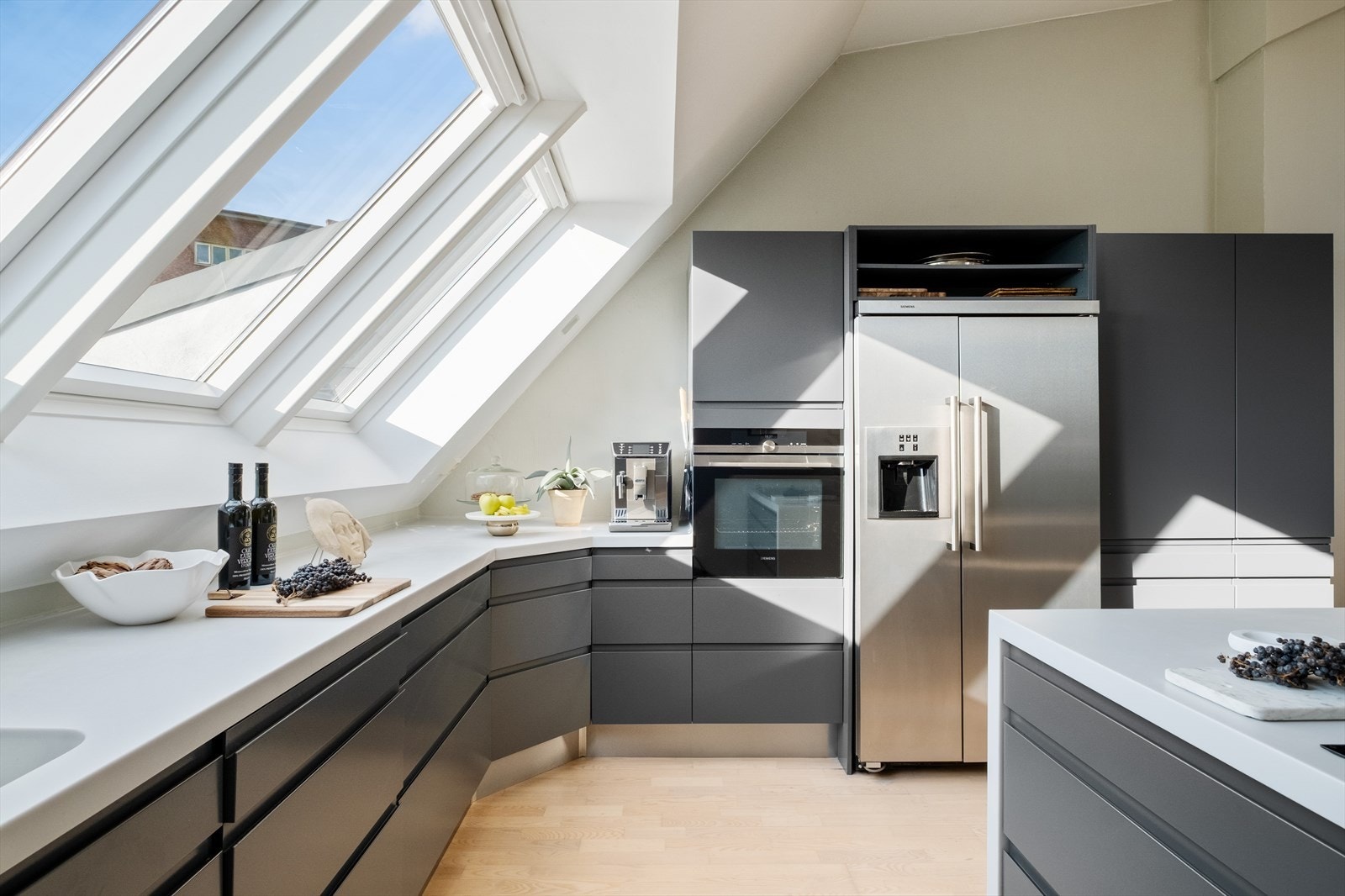 Kjøkkenet har en helstøpt Corian benkeplate med støpt vaskekum, nedfelt induksjonstopp, stekeovn og oppvaskmaskin fra Siemens. Lekker nedfellbar avtrekksvifte fra Gaggenau. Galleribilde