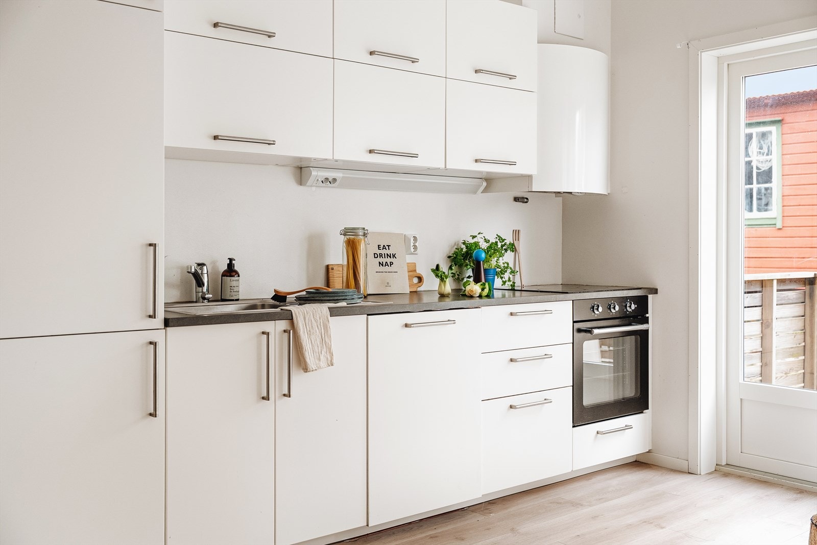 Klassisk og stilrent kjøkken med slette fronter og laminat benkeplate. Galleribilde