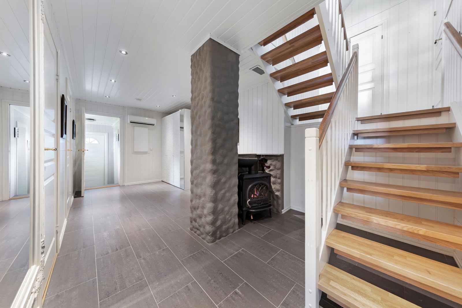 Romslig hall med varmekabler, vedovn og varmepumpe som oppvarming Galleribilde