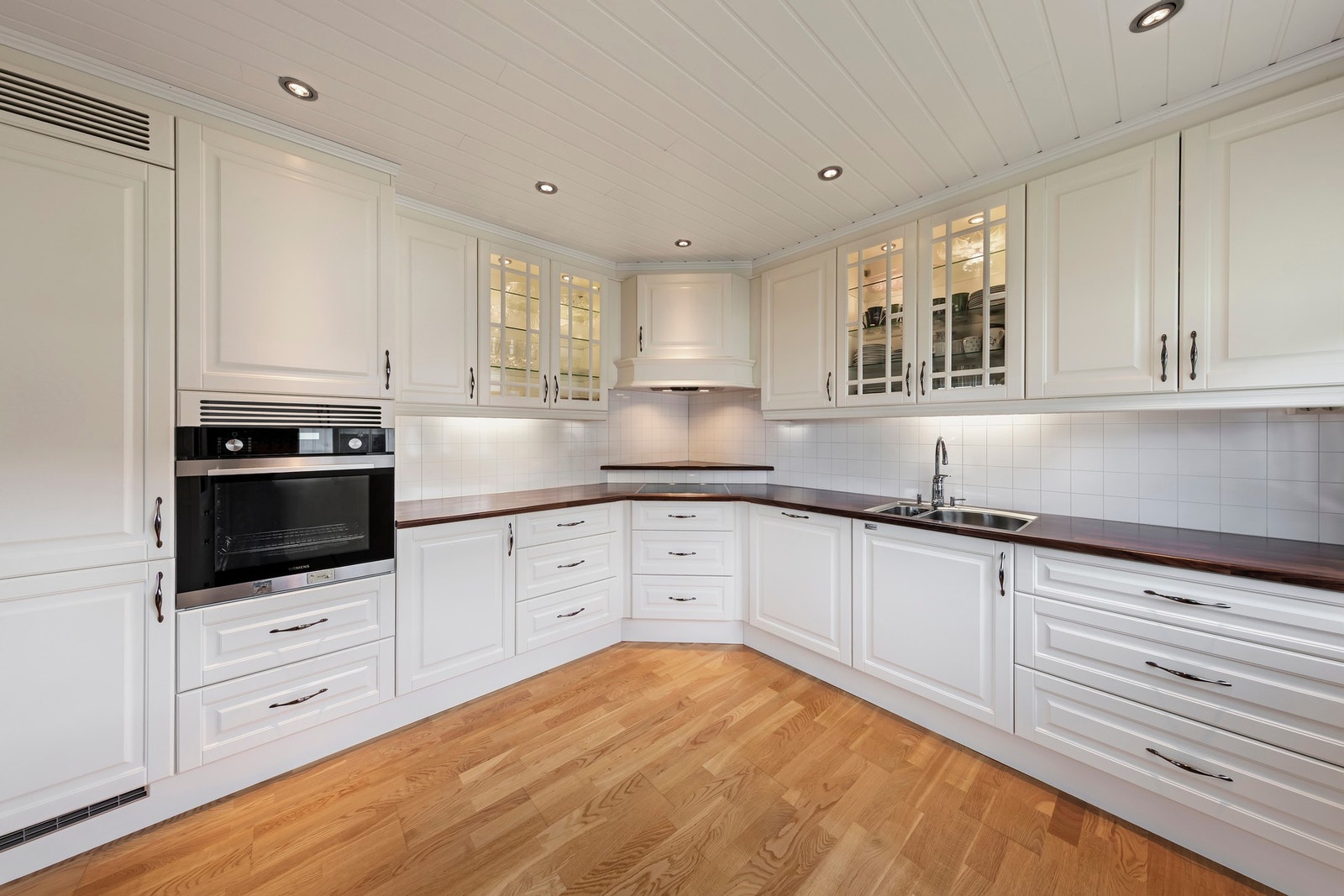 Kjøkkenet har integrerte hvitevarer som stekeovn, induksjonstopp, oppvaskmaskin og kjøl-/fryseskap Galleribilde