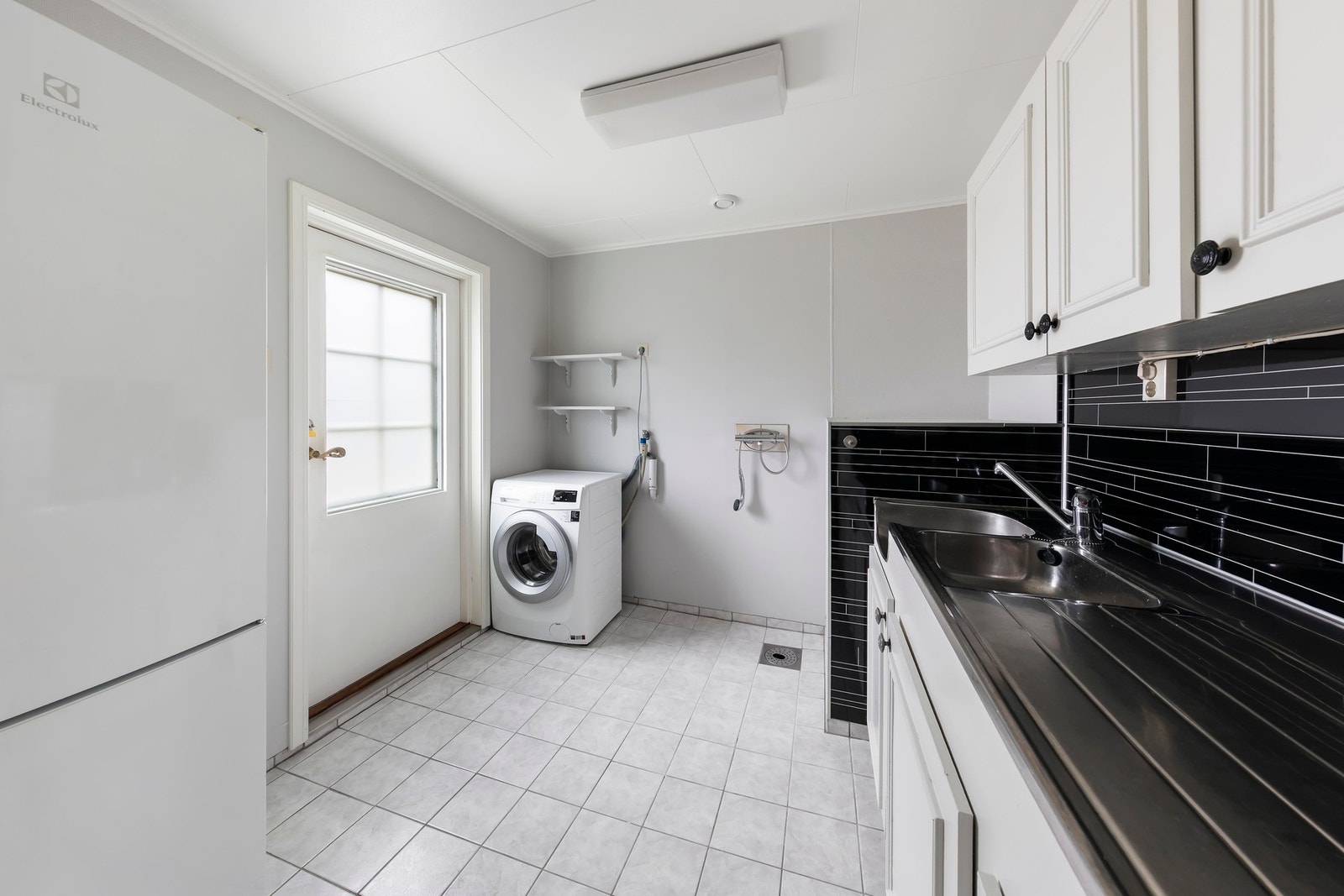 Vaskerommet har flislagt gulv med varmekabler. Innredning med heldekkende benkebeslag. Opplegg for vaskemaskin og termostatstyrt dusjarmatur Galleribilde