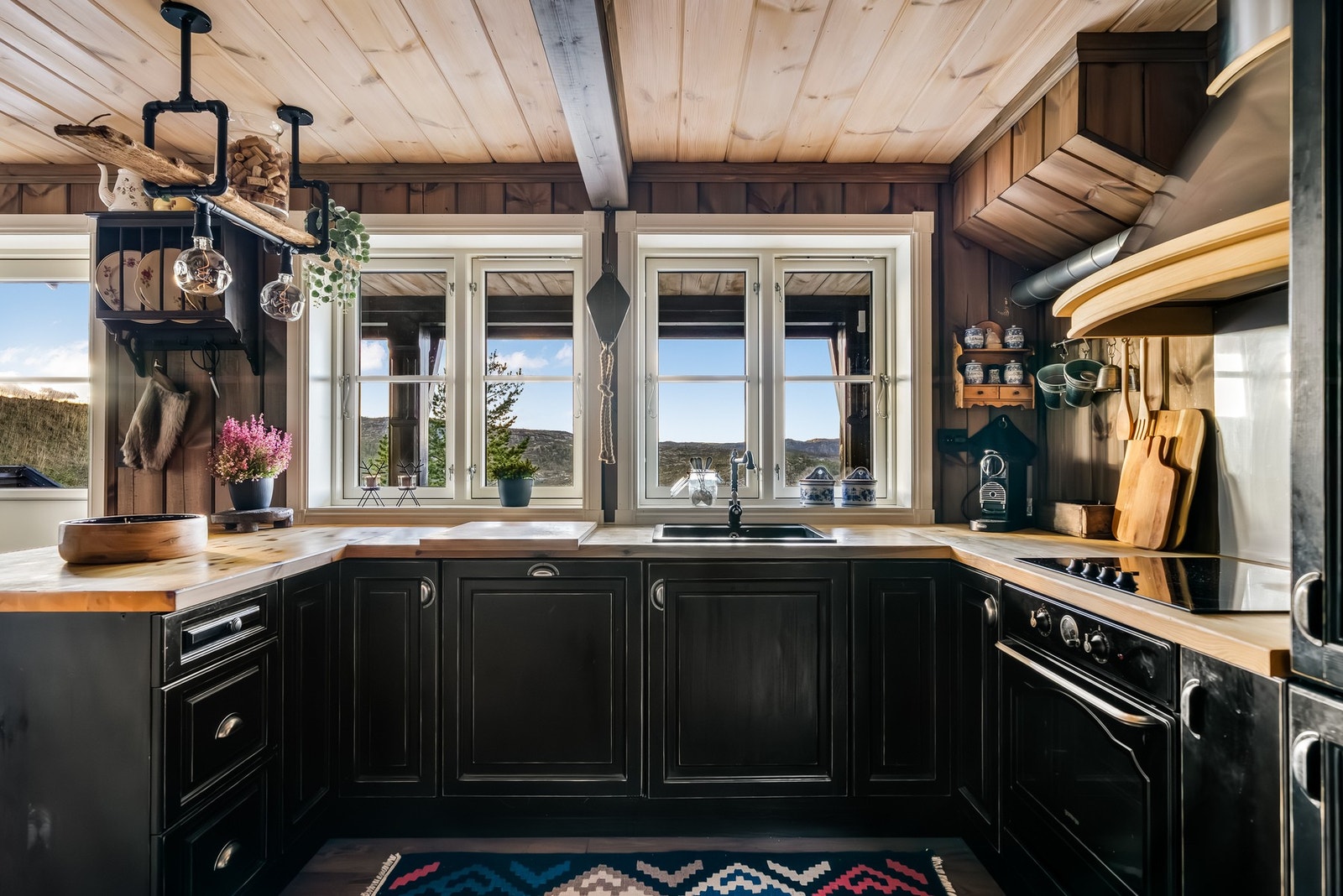 Kjøkkeninnredning med profilerte fronter og benkteplate i heltre. Flott utsikt mot fjellheimen via to store vinduer. Galleribilde