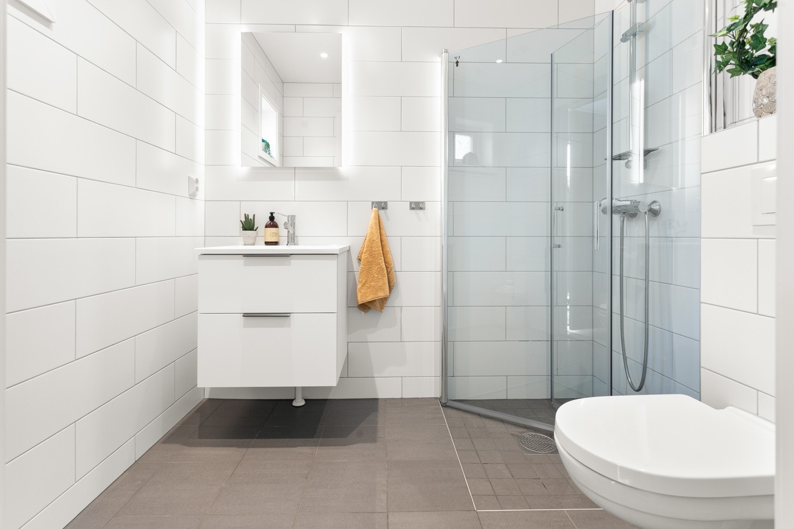 I husets 1. etasje har har du et moderne og lyst bad med dusj, toalett og baderomsinnredning. Flott vegghengt speil med belysning! Galleribilde