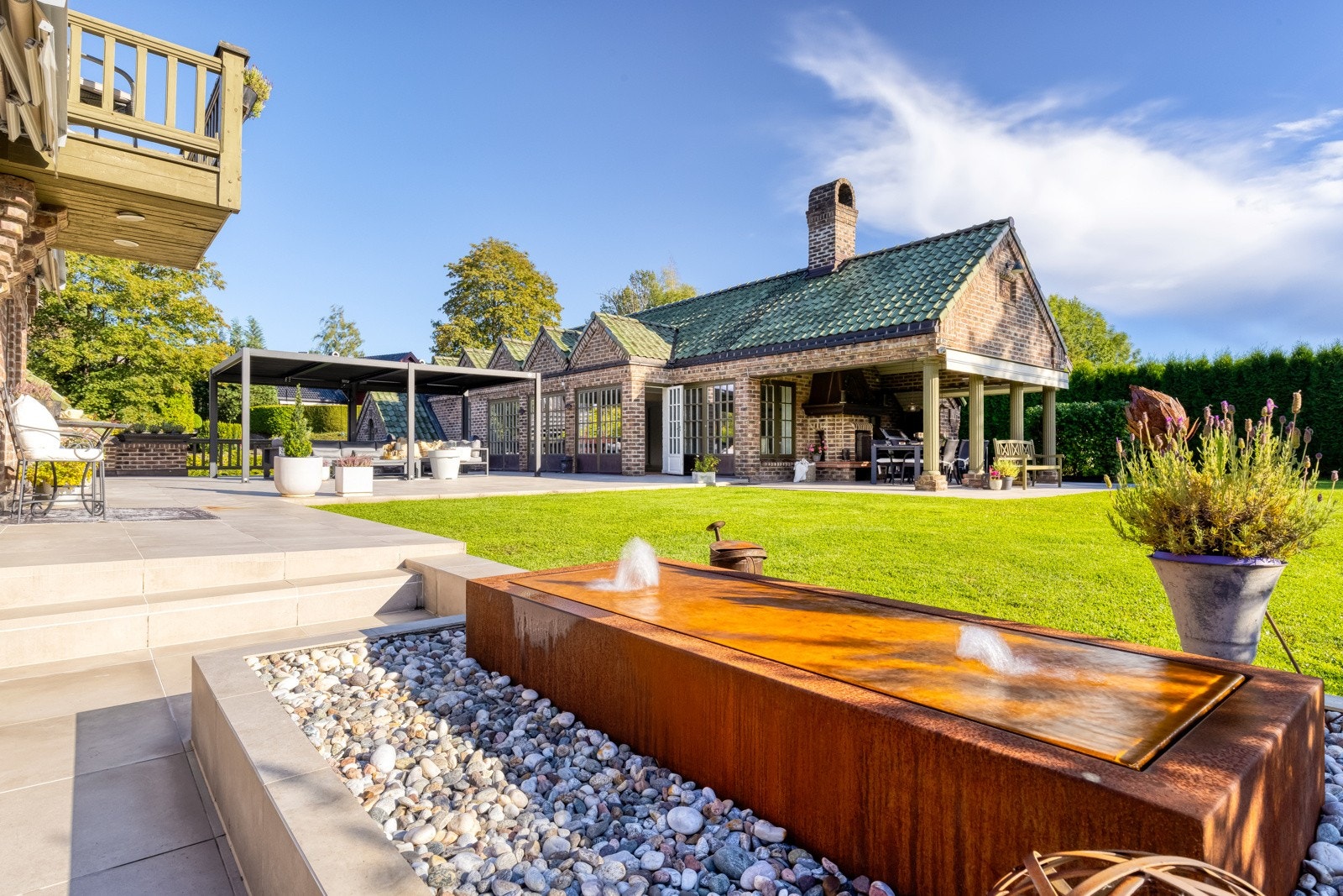 Fra både stue og kjøkken er det utgang til eiendommens fantastiske uteområde. Et totalt skjermet og frodig atrium med hage og bassenghus.