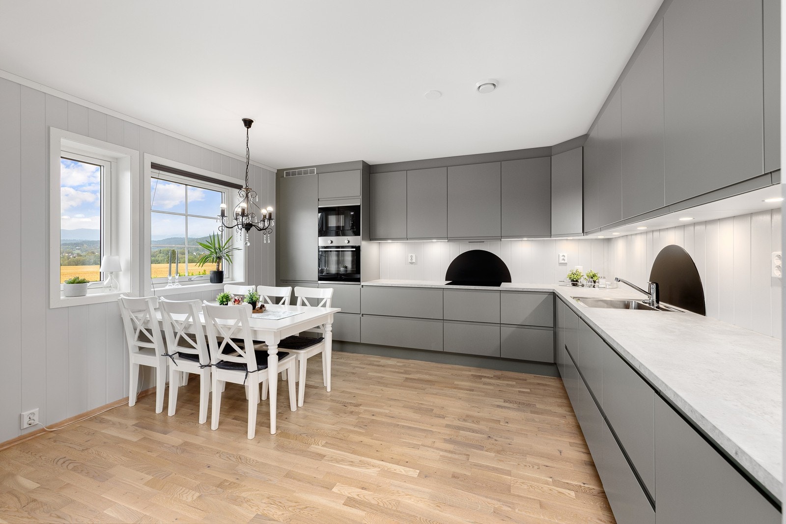 Spiseplassen har naturlig tilknytning til kjøkkenet, som er innredet med delikate, glatte fronter og laminat benkeplate. Galleribilde