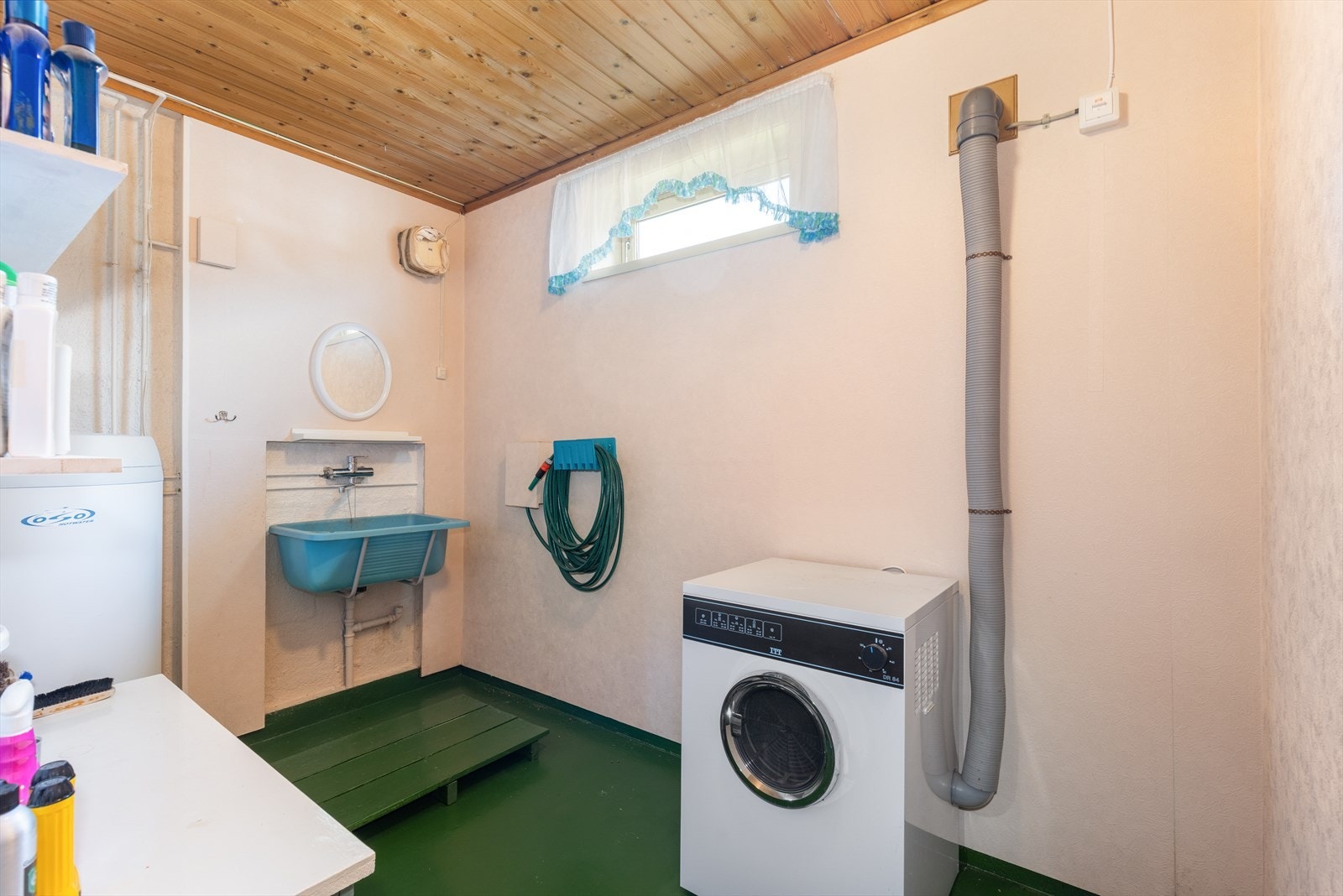 Vaskerom av eldre standard, utstyrt med opplegg for vaskemaskin og vegghengt vaskekar i plast. Varmtvannstank fra 2015. Galleribilde