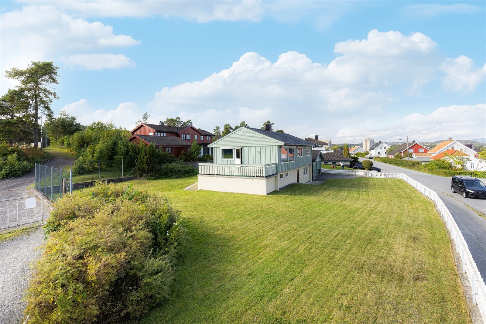 Stedvis langs tomtens grenser er det forstøtningsmur av betong, med stakittgjerde over. Galleribilde