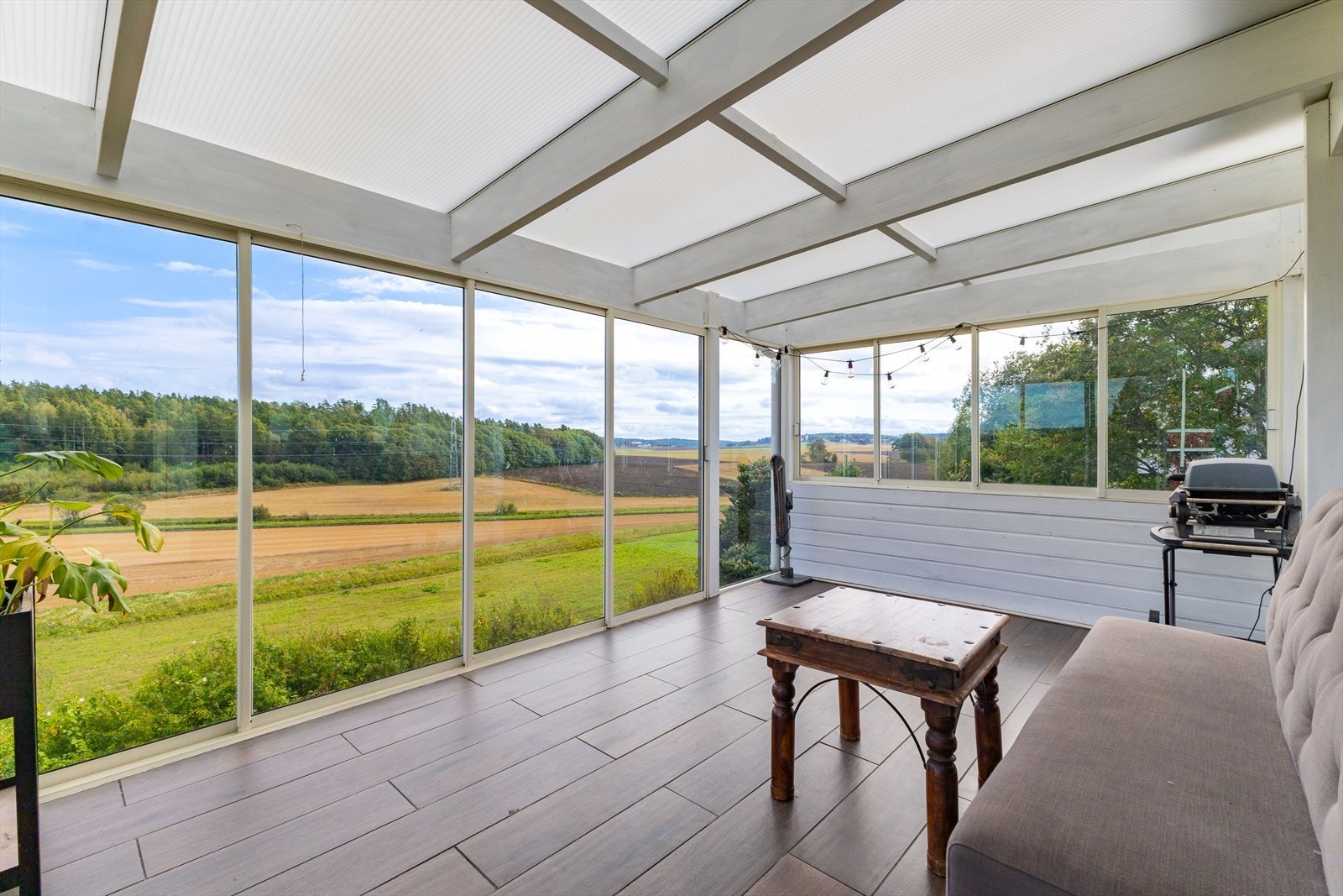 Nydelig, landlig utsikt fra et tiltalende stueområde og vinterhage. Galleribilde