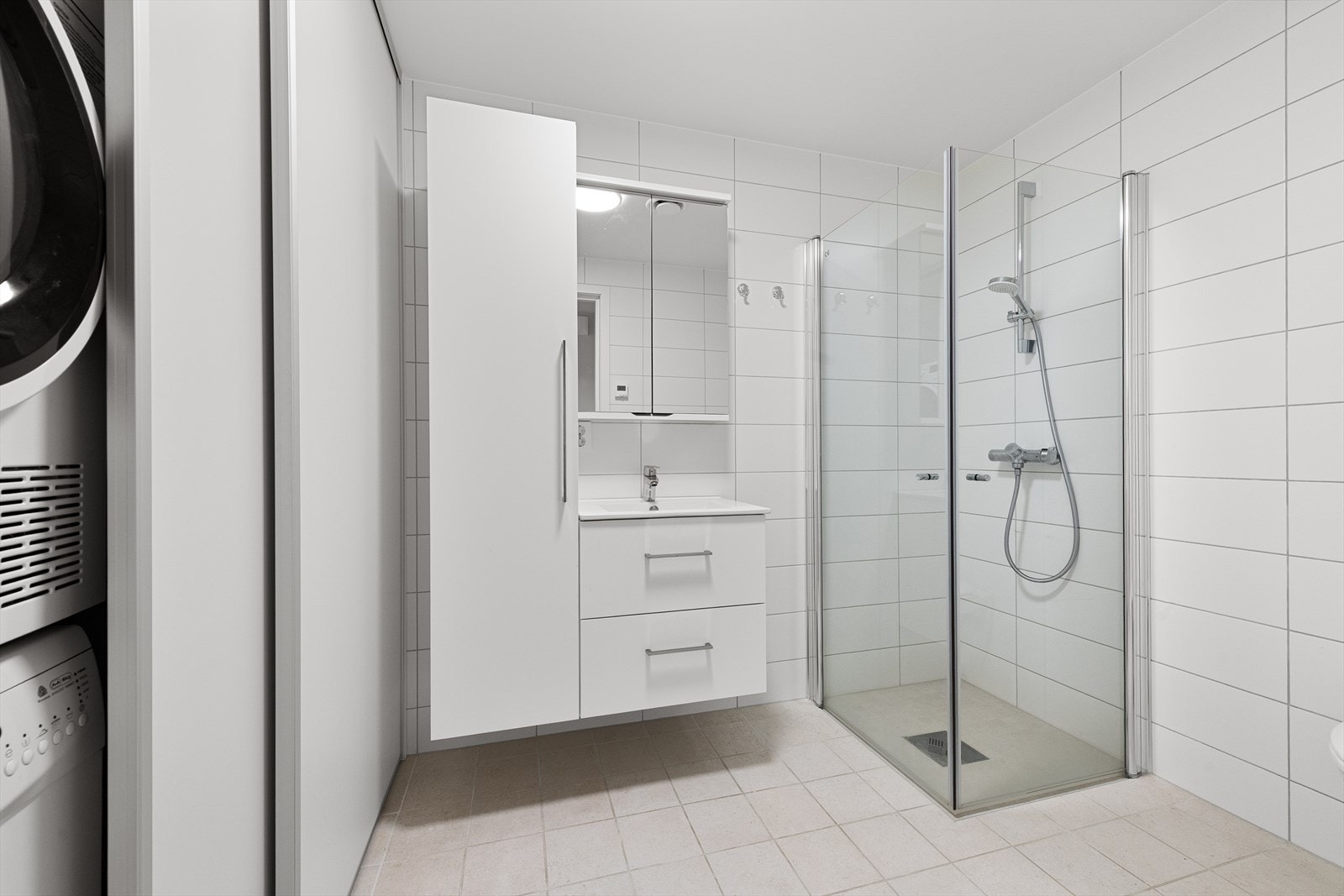 Bad med innfellbare dusjvegger, innredning m/høyskap og smart vaskeromsløsning bak skyvedører. Galleribilde