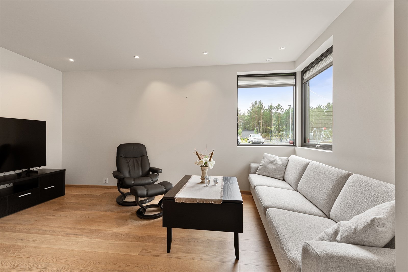 Vinduer i stue har tilpasset solskjerming. Det er spotter i tak. Galleribilde