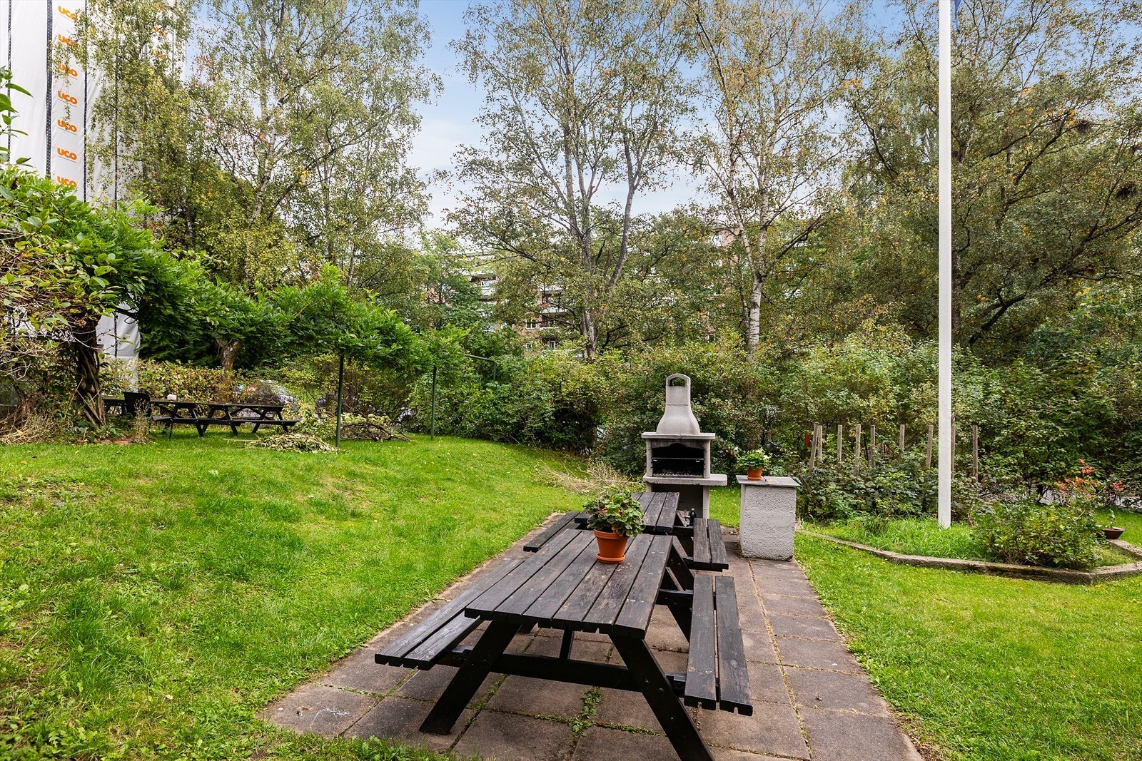 Stort fellesareal opparbeidet med asfalterte adkomstveier/plasser, gressplen, beplantning, parkeringsarealer m.m. Galleribilde