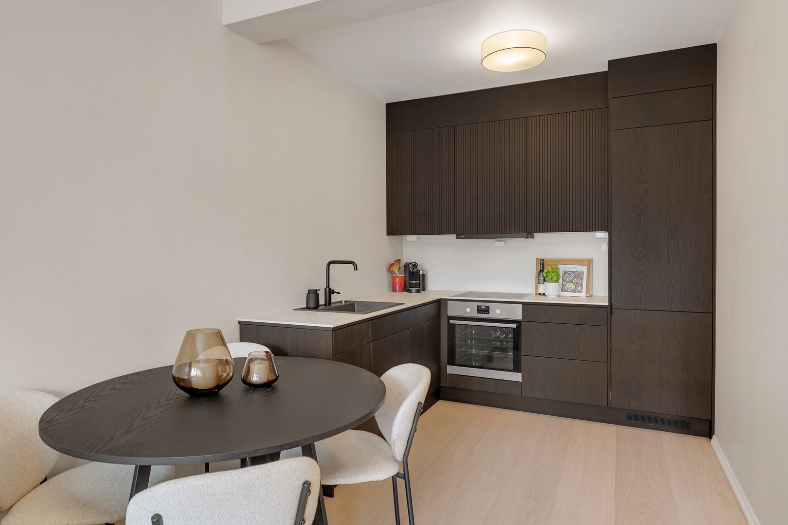 Kjøkkeninnredningen er utført med glatte og rillede fronter, benkeplate i stein fra nerostein med oppvaskkum og 1-greps blandebatteri. Galleribilde