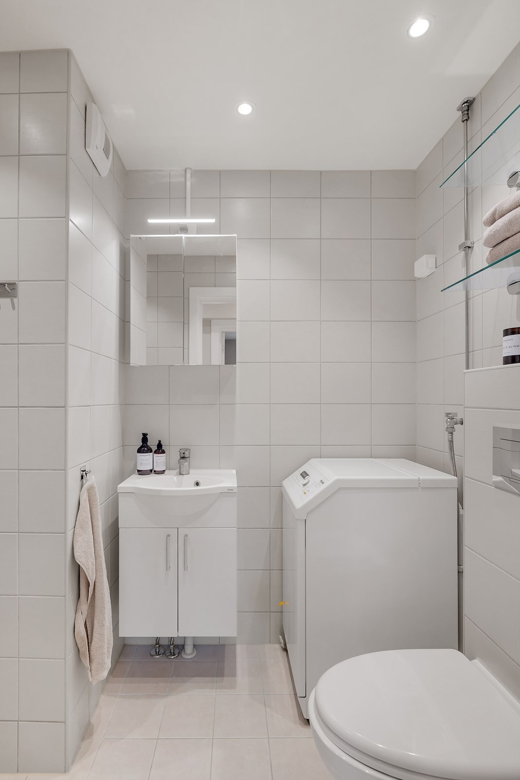 Lyst, flislagt baderom i tidløs stil, med varmekabler i gulvet og downlights i himling. Baderommet ble oppgradert i 2018, i regi av sameiet. Galleribilde