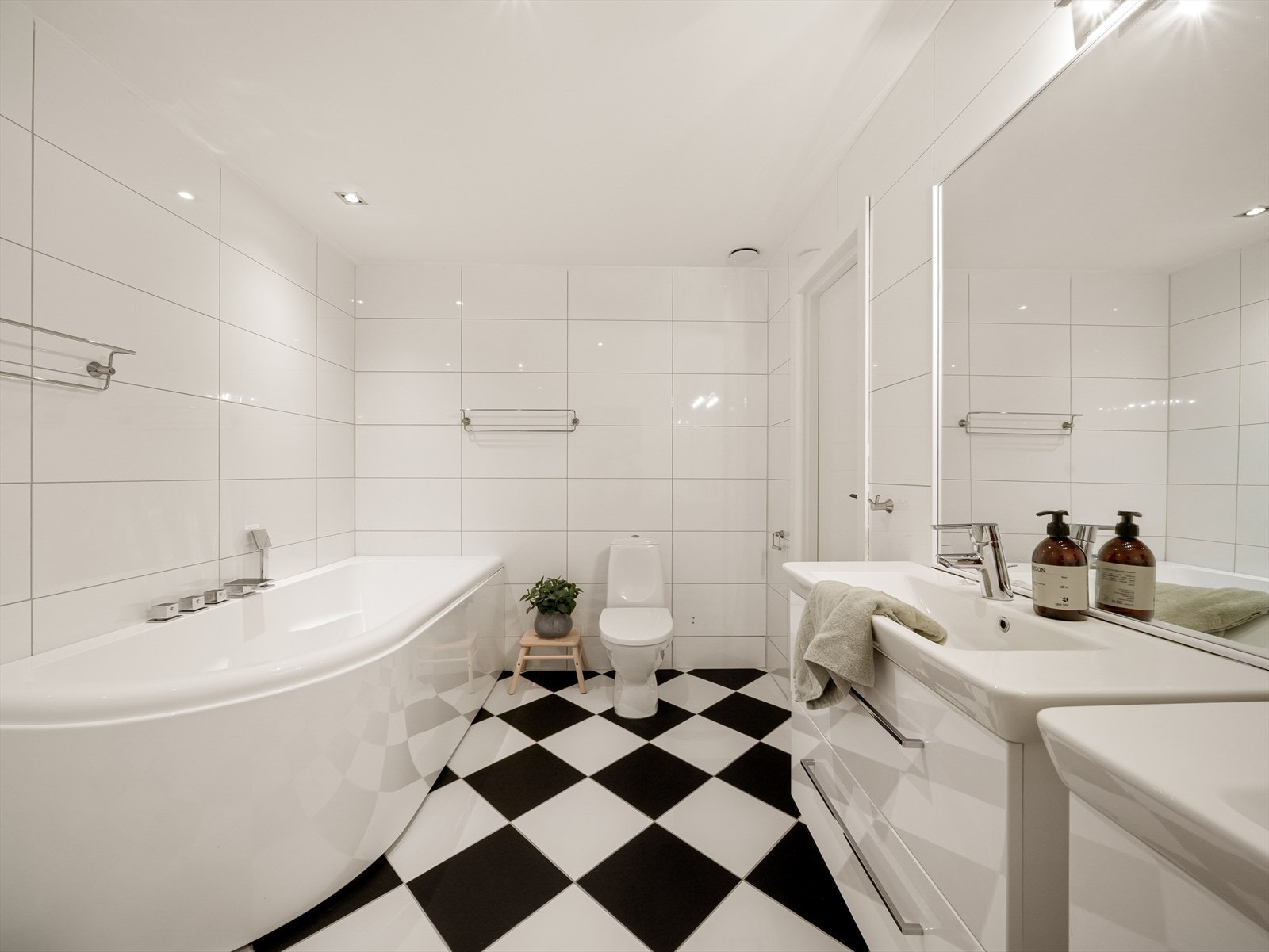 Badet er helfliset og er innredet med baderomsinnredning med dobbel servant, toalett, dusj og badekar. Galleribilde