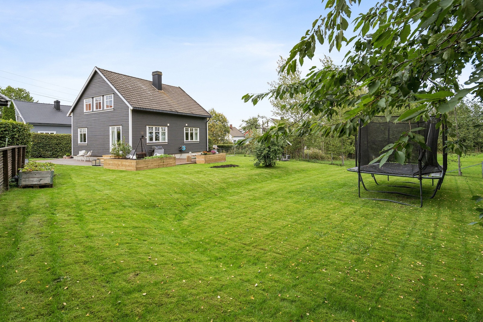 Det er en stor hagetomt med friareal/ lekeplass som nærmeste nabo vis-á-vis eiendommen. Galleribilde