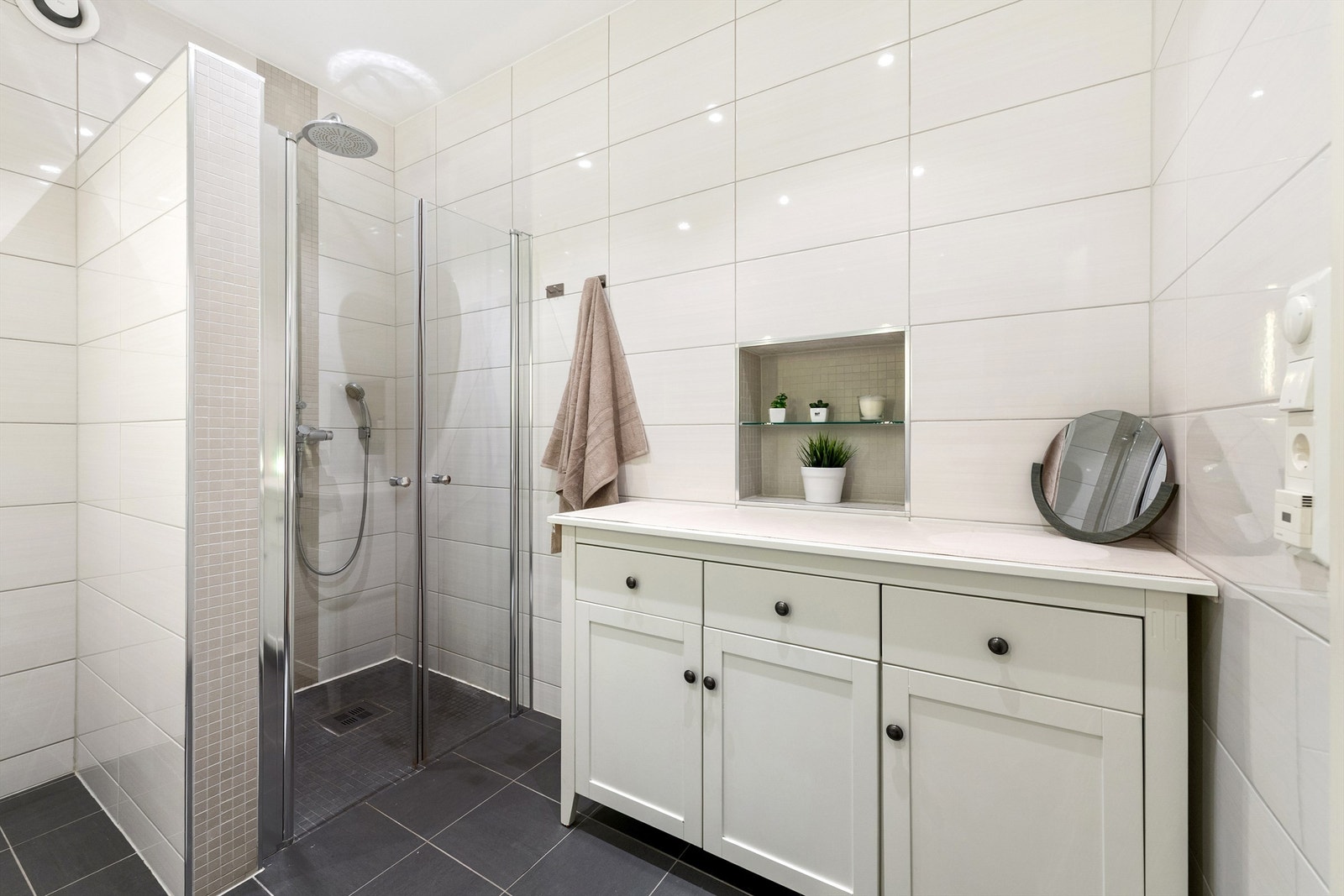 Badet ble oppgradert i 2013/2014 og har flislagt gulv med gulvvarme, flislagte vegger og malt tak. Dusjnisje med glassvegger og vegghengt dusjarmatur med hånddusj og regndusj. Mekanisk avtrekksvifte i vegg. Galleribilde