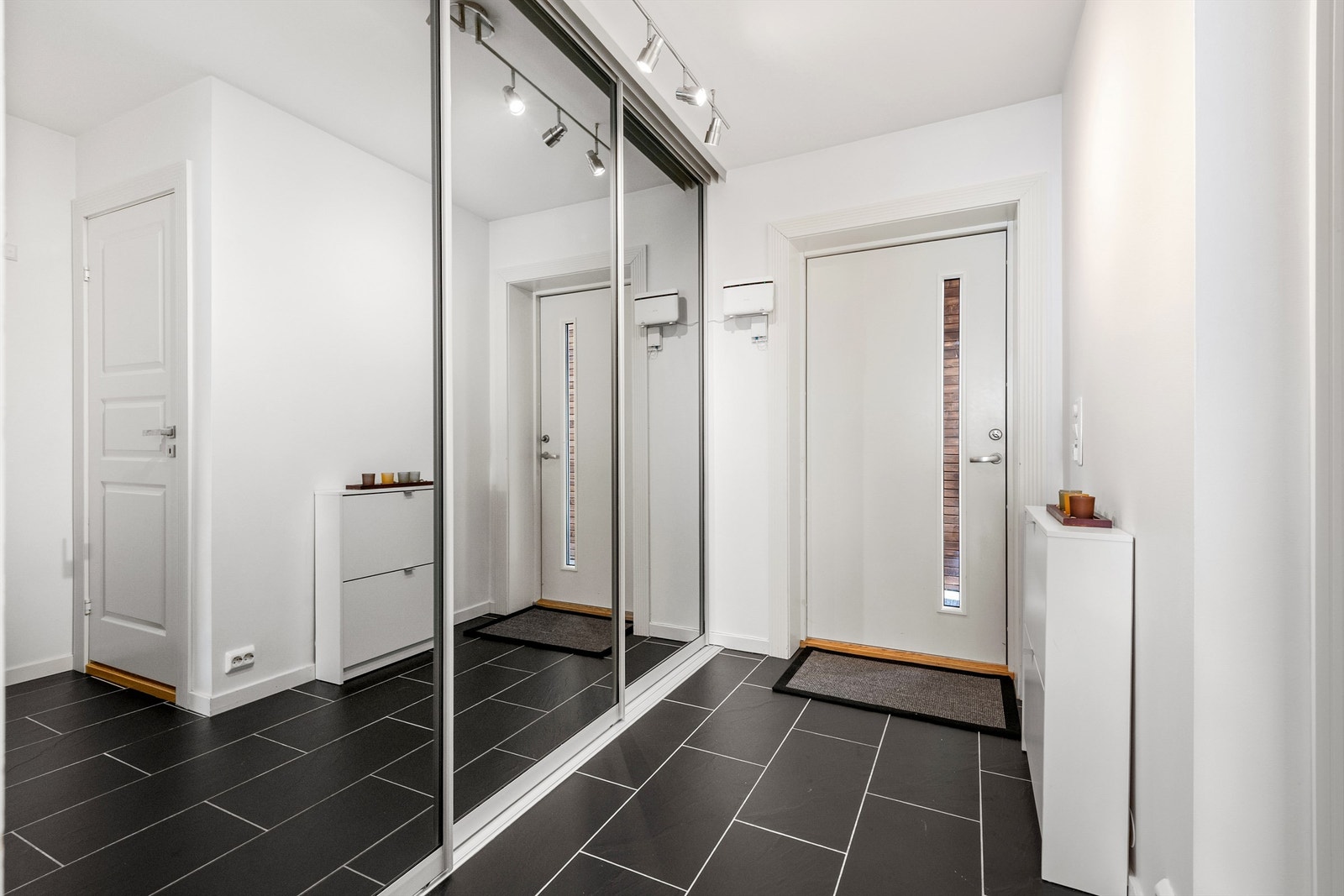 Inngangsparti og entre med skyvedørsgarderobe med gode oppbevaringsmuligheter til yttertøy og sko Galleribilde