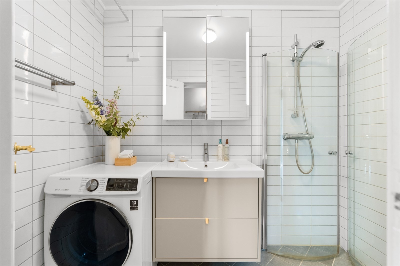 Badet er utstyrt med veggmontert wc, innfellbare dusjdører og servantskap med ett greps blandebatteri fra FM Mattsso. Galleribilde