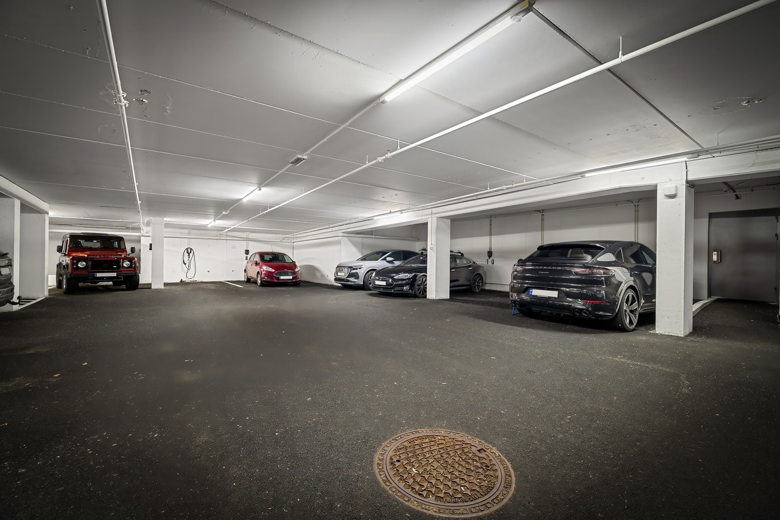 Det medfølger også fast plass i garasjeanlegget. Det er montert lader til el-bil på denne plassen. Galleribilde