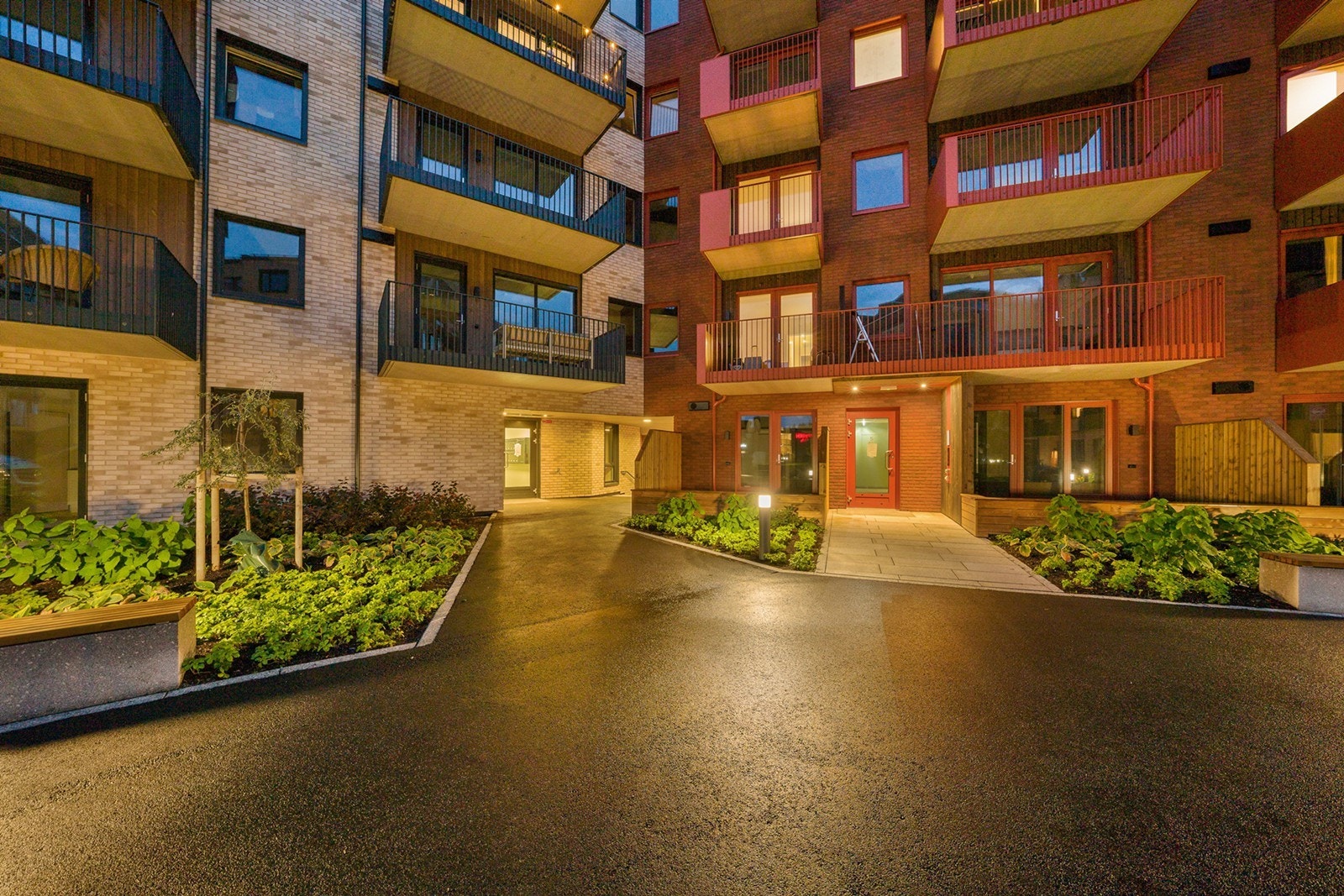 Pent opparbeides fellesareal med sitteplasser og grønne planter Galleribilde