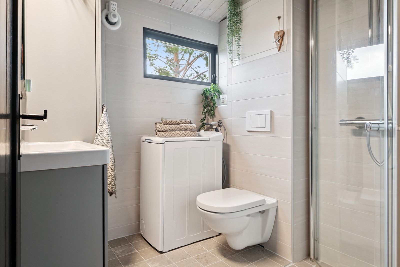 Dusjhjørne med innfellbare glassdører utnytter plassen på badet optimalt. Galleribilde