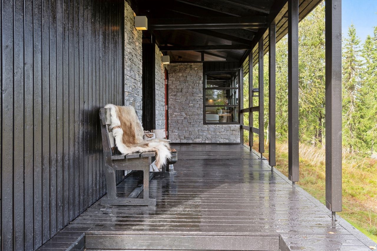 Overbygget terrasse ved inngangspartiet gir en lun og skjermet ankomst til hytta. Galleribilde
