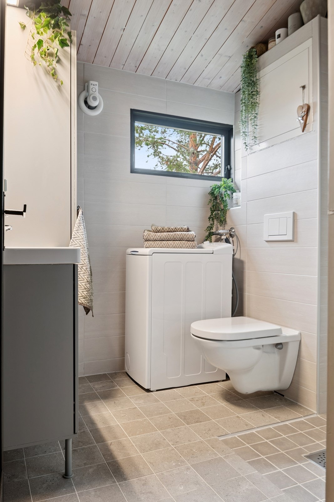 Praktisk innredet bad med vegghengt toalett og opplegg for vaskemaskin. Galleribilde