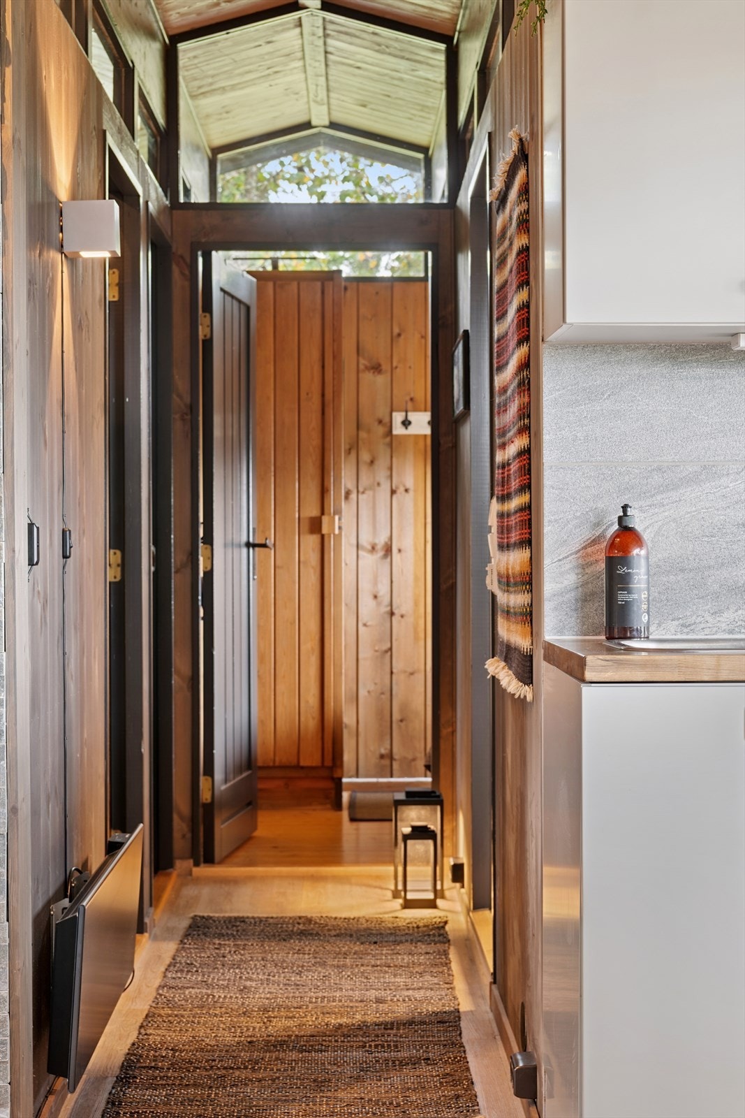 Gjennomgående trepanel, beiset i 2025, skaper en varm og autentisk hyttefølelse. Galleribilde