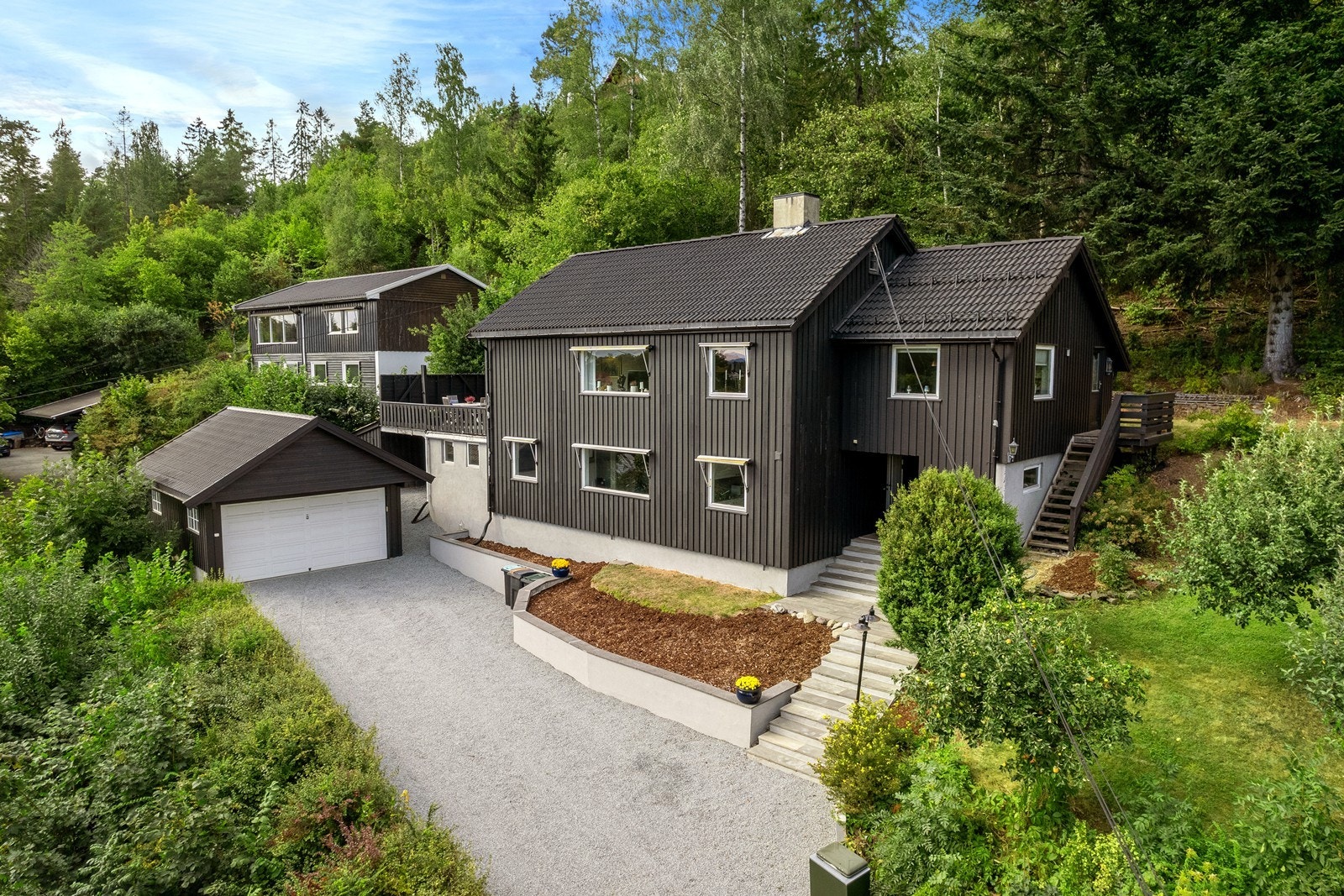 Gruset gårdsplass og pent opparbeidet have og naturtomt Galleribilde