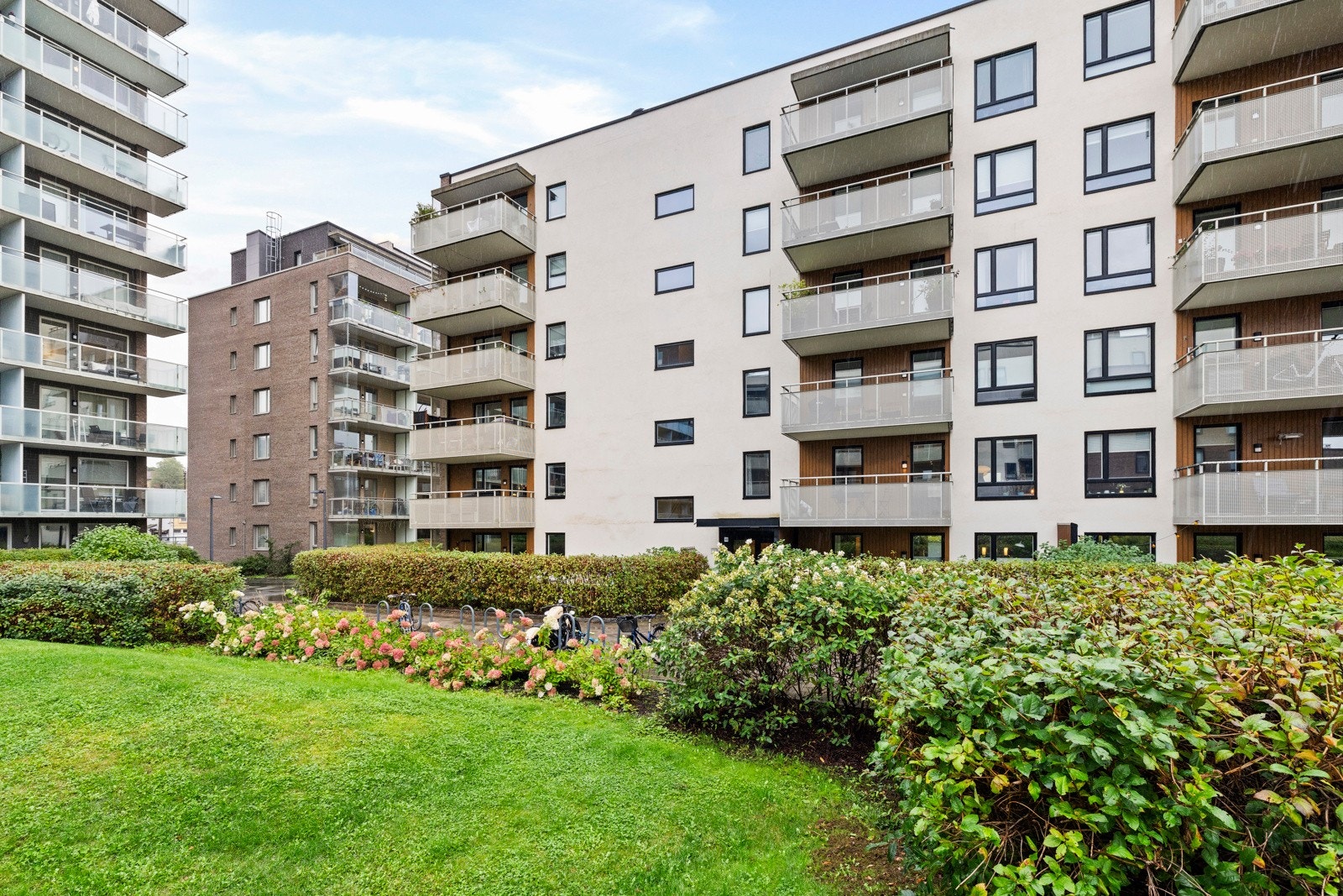 Store fellesareal som er pent opparbeidet med asfalterte adkomstveier/plasser, steinbelagte arealer, gressplen, beplantning, lekeplasser m.m. Galleribilde