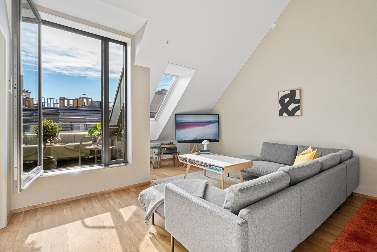 Store vindusflater sørger for mye naturlig lys inn i leiligheten. Galleribilde